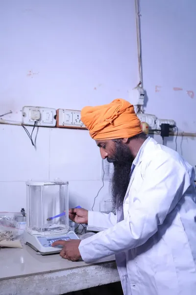 A technician weighing a feed sample on the analytical balance