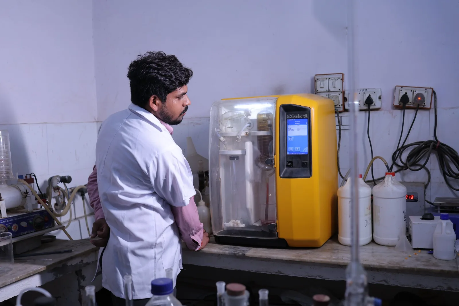 A quality technician running a feed sample on the protein analyser in the in-house laboratory